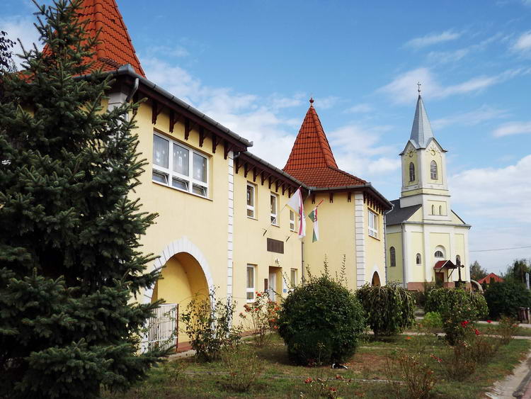 Nyírlugos - Az óvoda és teleház épülete a katolikus templom mellett áll