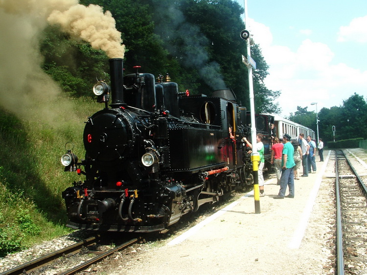 Two steam-engines pull the long train on the hard upward slope
