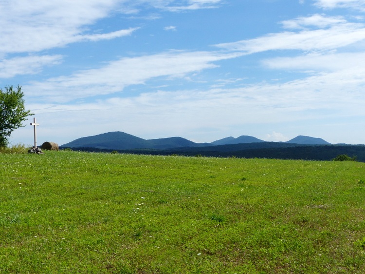 The Sátor-hegyek Mountains appears above the back of the grassy hill