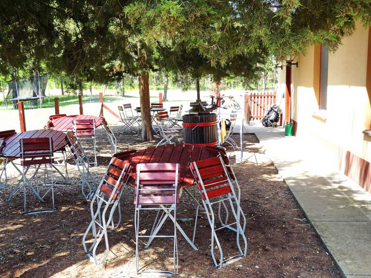 A Pici-paci-tanya éplete előtti árnyas kerti asztalok