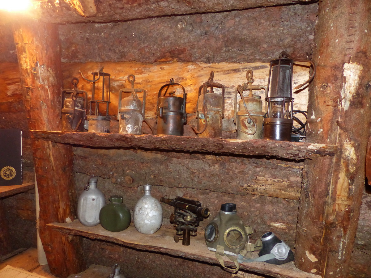 Karbidlámpák, kulacsok, gázálarcok és egy régi teodolit egy durván ácsolt polcon
