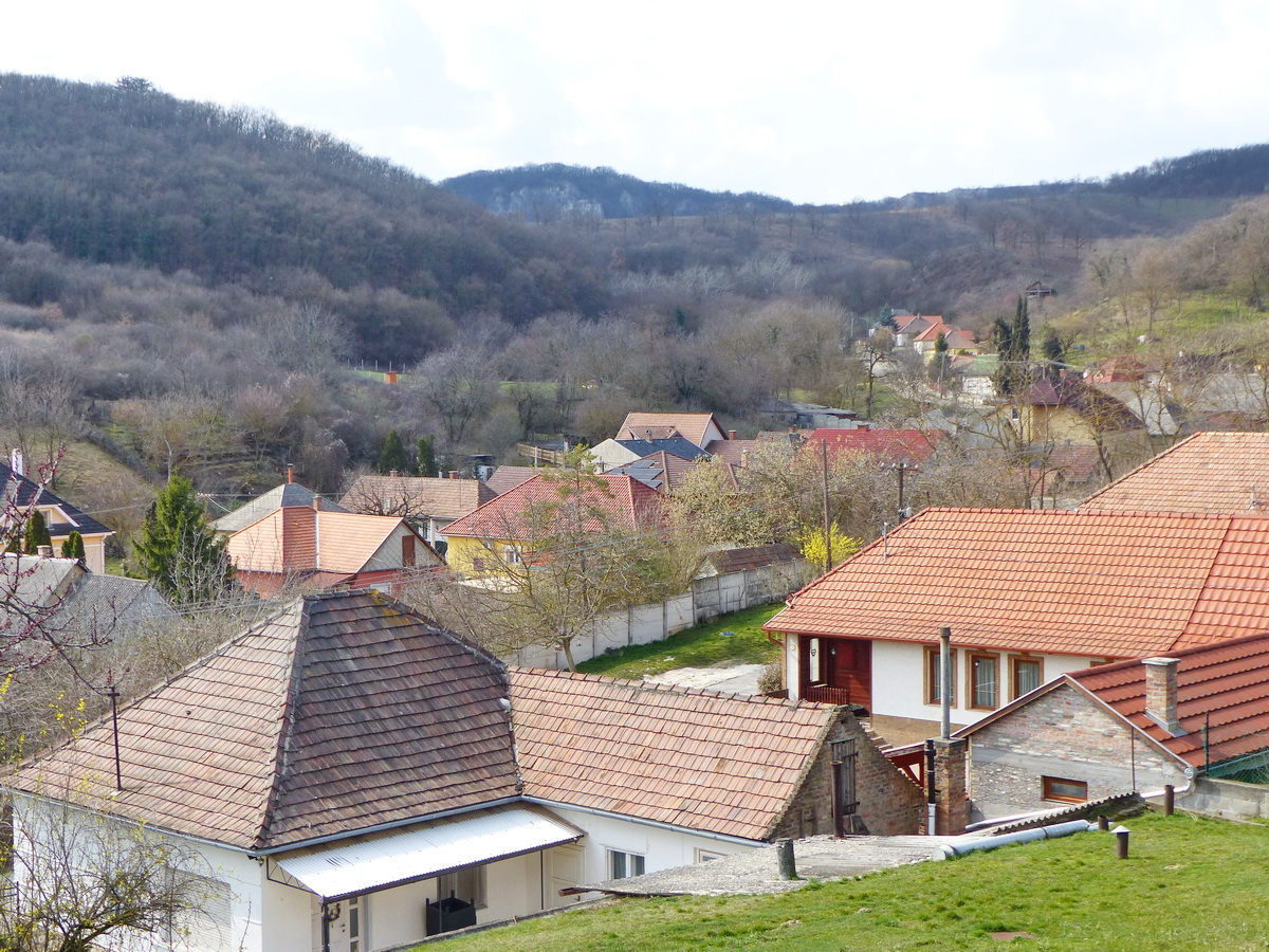 Mogyorósbánya háztetői felett már jól látszik hátul középen a Bajóti Öreg-kő
