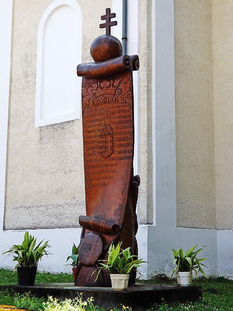 A templom mellett áll a „Nemes” előtagú településeket felsoroló faoszlop A templom mellett áll a „Nemes” előtagú településeket felsoroló faoszlop