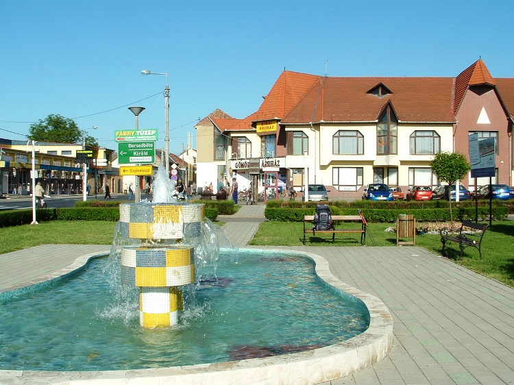 The building of Gömör Áruház stands beside a small park