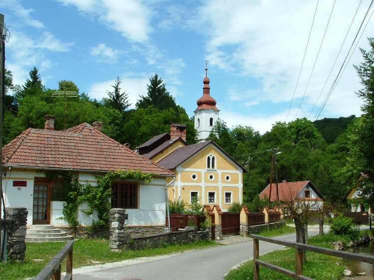 The tower of the church stands in the hillside in Jósvafő