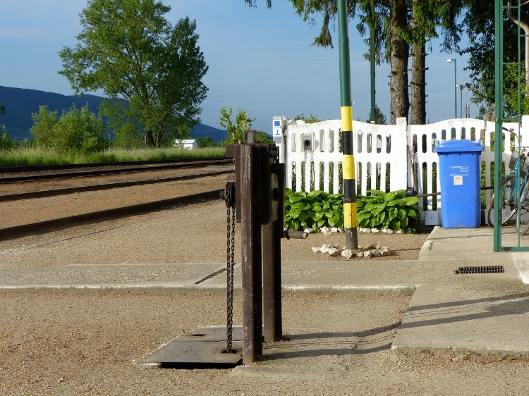 A kéktúra pecsét dobozkája a fehérre meszelt vasúti kerítésre van szerelve