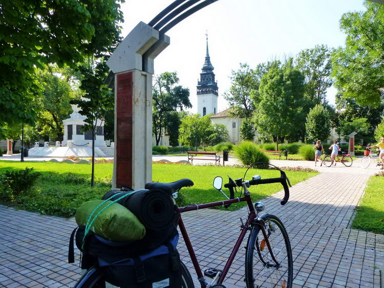 Megálltam egy pihenőre a Hősök tere parkjában. A háttérben feltűnik a református templom tornya.