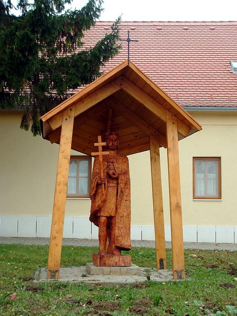 Királyszobor Csénye főutcáján, a templom mellett