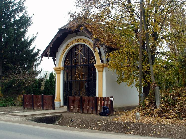 Parányi kápolna a főút szélén. A kéktúra bélyegző dobozkája az előtte lévő korlátra van szerelve.